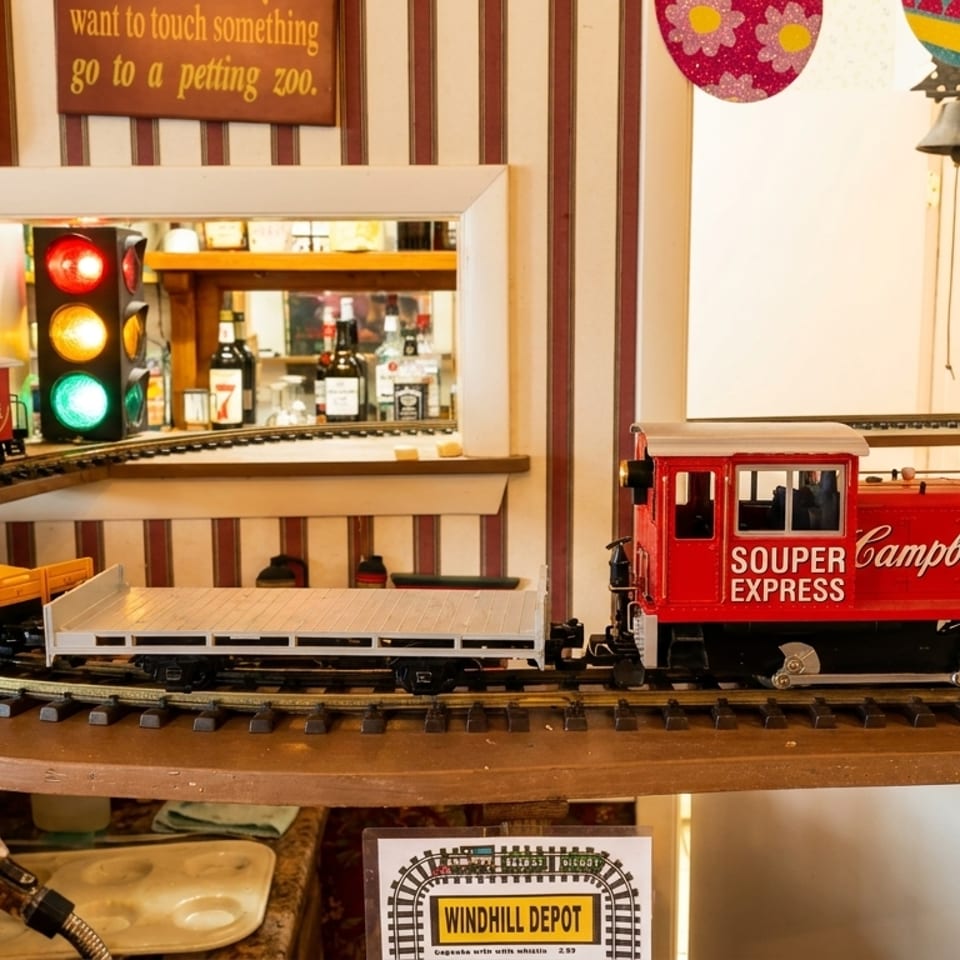 A model train, the "Souper Campbell's Express," on a track in a whimsical restaurant setting.